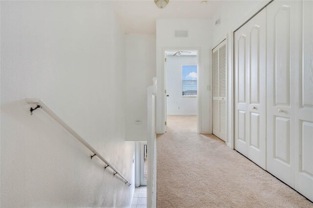 corridor featuring light colored carpet