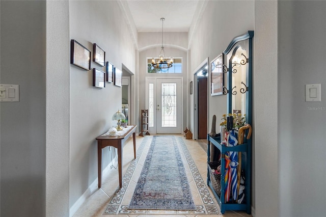 foyer with an inviting chandelier and light tile patterned flooring