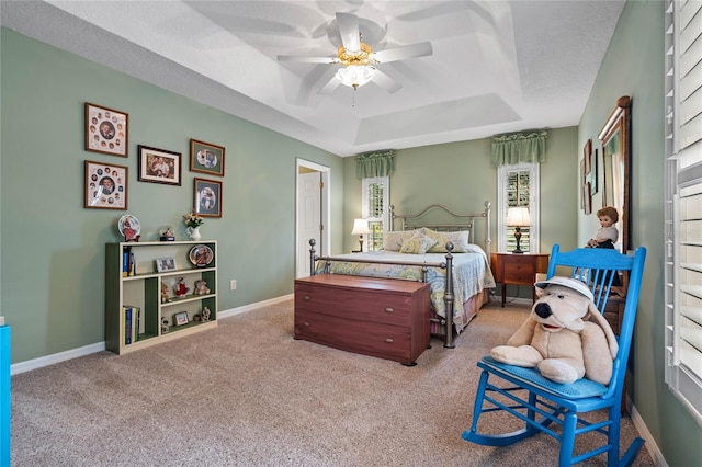 bedroom featuring a tray ceiling, ceiling fan, and light carpet