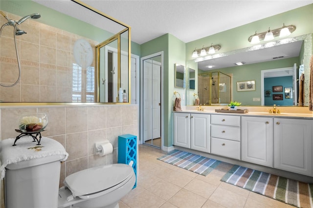 bathroom featuring a textured ceiling, vanity, an enclosed shower, tile patterned flooring, and toilet