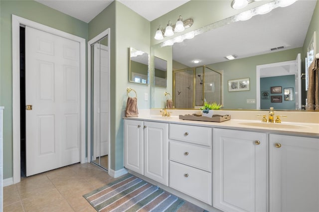 bathroom featuring a shower with door, vanity, and tile patterned floors