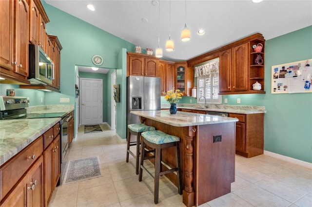 kitchen with light tile patterned floors, stainless steel appliances, a center island, light stone countertops, and sink