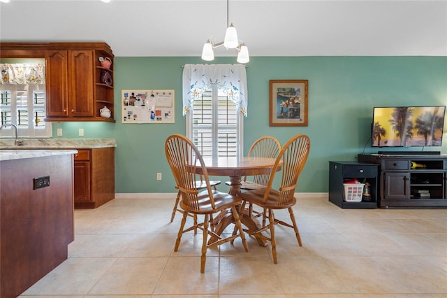 dining room featuring a wealth of natural light, sink, a chandelier, and light tile patterned flooring