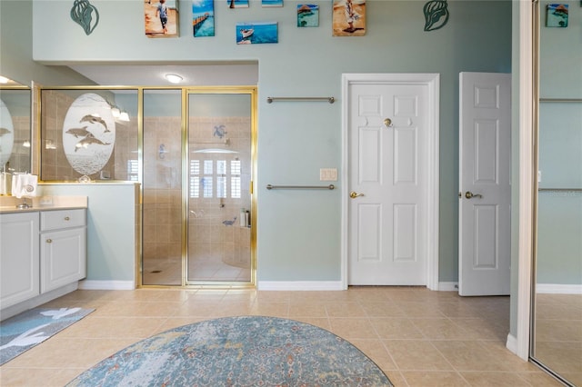 bathroom with a shower with door, vanity, and tile patterned flooring