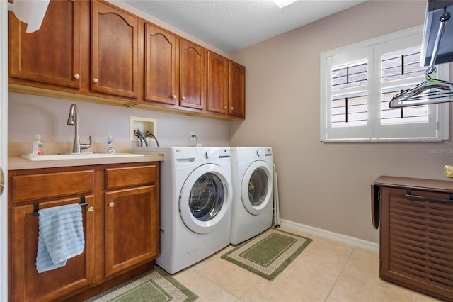 washroom with cabinets, washer and clothes dryer, sink, and light tile patterned floors