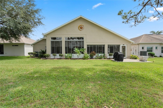 rear view of house featuring cooling unit, a yard, and a sunroom