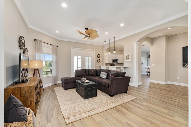 living room with crown molding, light hardwood / wood-style flooring, and ceiling fan