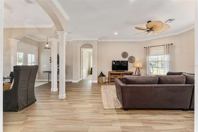 living room with ornamental molding, ceiling fan, and decorative columns