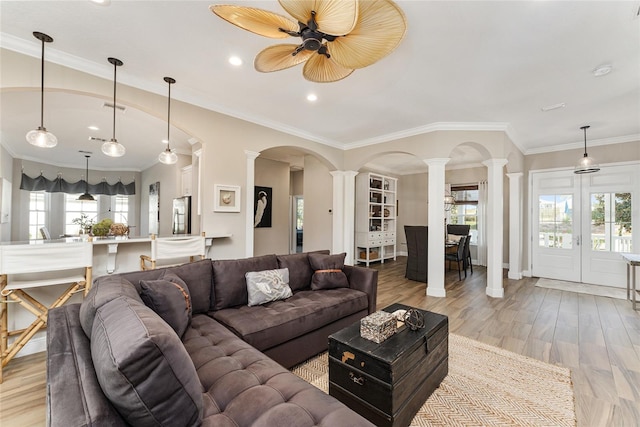 living room featuring plenty of natural light, ceiling fan, ornamental molding, and decorative columns