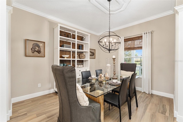 dining room with an inviting chandelier, light hardwood / wood-style floors, and crown molding