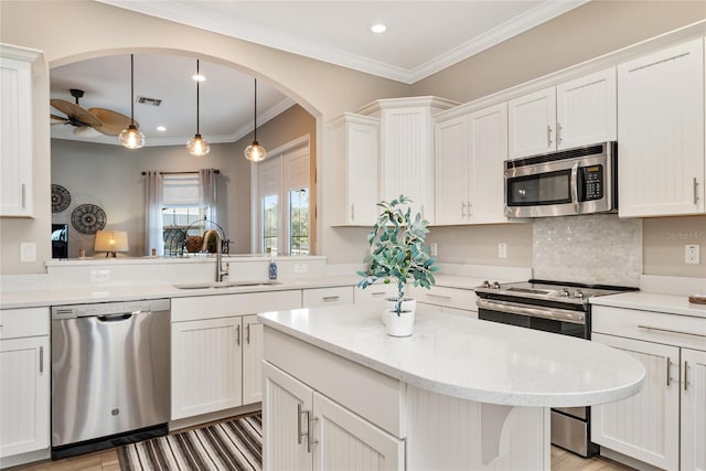 kitchen featuring white cabinets, decorative light fixtures, appliances with stainless steel finishes, sink, and ceiling fan