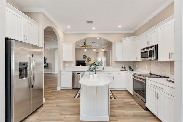 kitchen featuring hanging light fixtures, stainless steel appliances, light wood-type flooring, and a kitchen island