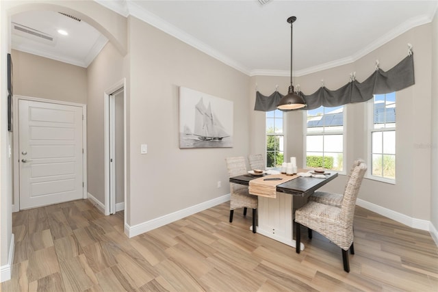 dining space with light hardwood / wood-style flooring and ornamental molding