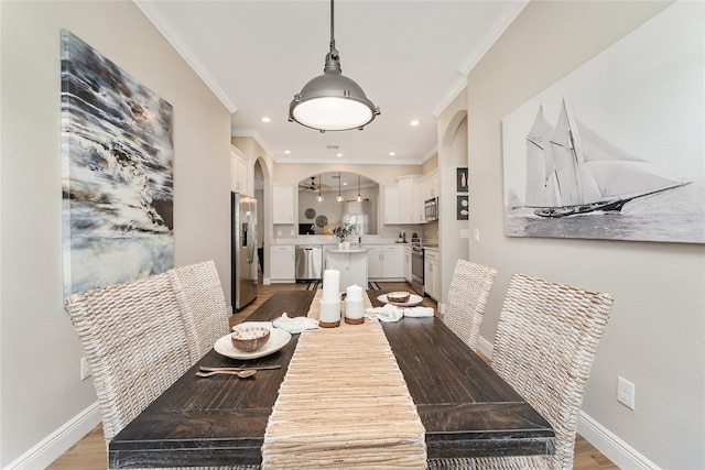 dining space with light hardwood / wood-style floors and crown molding