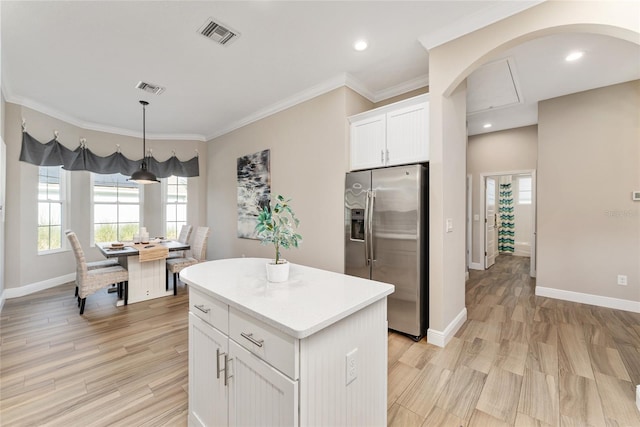 kitchen featuring a center island, stainless steel fridge, white cabinets, and light hardwood / wood-style floors