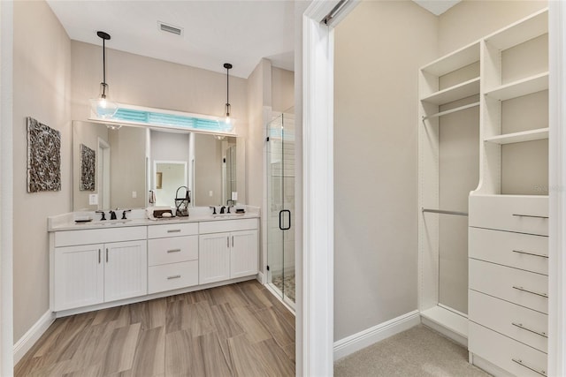 bathroom featuring vanity, a shower with shower door, and hardwood / wood-style floors