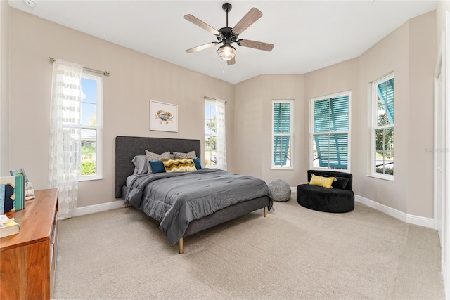 bedroom with light colored carpet, ceiling fan, and multiple windows