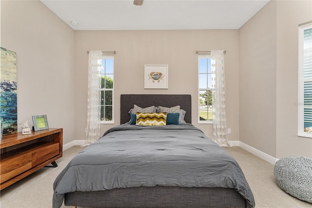 bedroom with carpet and multiple windows