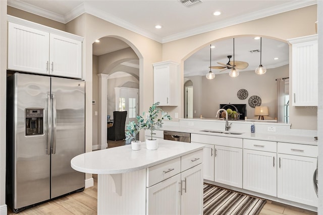 kitchen featuring light wood-type flooring, pendant lighting, white cabinetry, kitchen peninsula, and appliances with stainless steel finishes