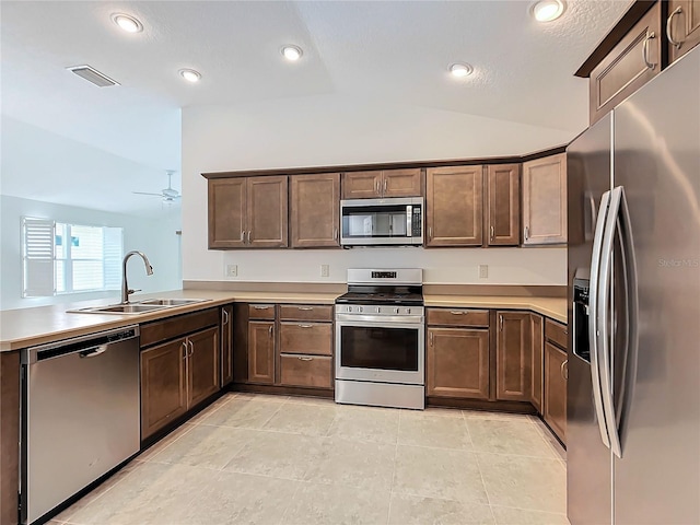 kitchen featuring vaulted ceiling, stainless steel appliances, sink, kitchen peninsula, and ceiling fan