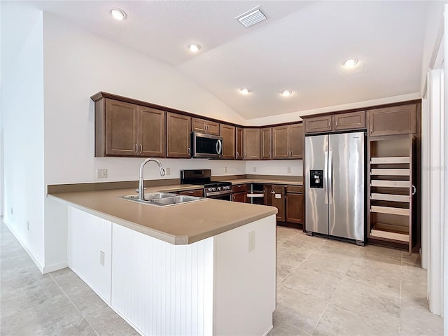 kitchen featuring stainless steel appliances, sink, kitchen peninsula, lofted ceiling, and dark brown cabinetry