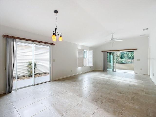 empty room featuring ceiling fan with notable chandelier, vaulted ceiling, and light tile patterned floors