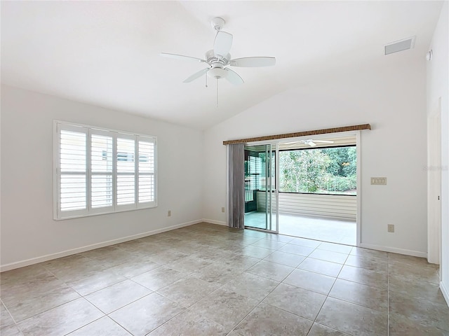 empty room featuring a healthy amount of sunlight, ceiling fan, light tile patterned floors, and vaulted ceiling