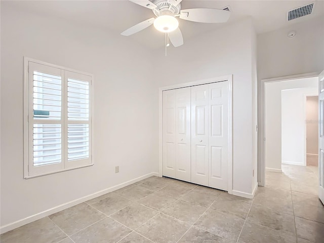 unfurnished bedroom with multiple windows, a closet, ceiling fan, and light tile patterned flooring