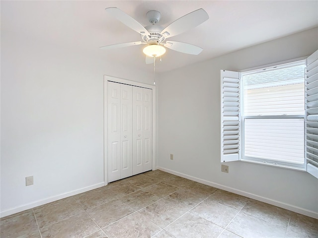 unfurnished bedroom with ceiling fan and a closet