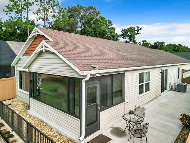 rear view of house featuring a sunroom, a patio area, and central AC unit