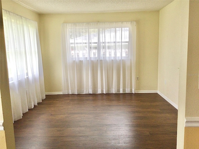 unfurnished room featuring a textured ceiling and dark hardwood / wood-style floors