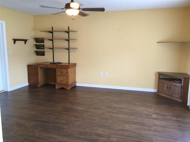 unfurnished living room featuring dark wood-type flooring and ceiling fan