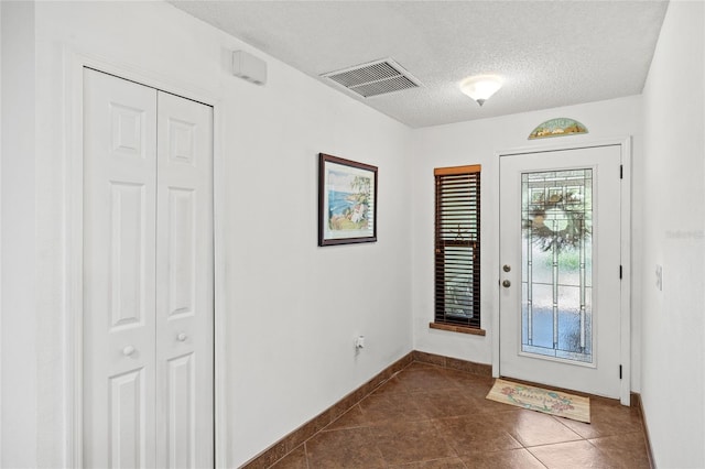 tiled foyer featuring a textured ceiling