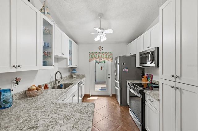 kitchen featuring stainless steel appliances, white cabinets, ceiling fan, and sink