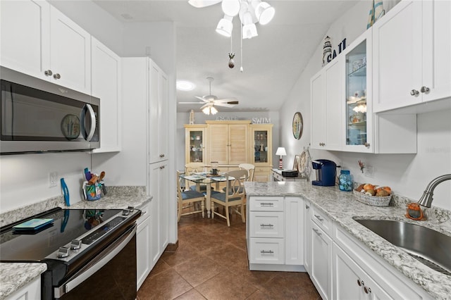 kitchen featuring ceiling fan, white cabinets, sink, dark tile patterned floors, and appliances with stainless steel finishes