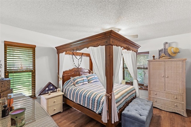 bedroom featuring ceiling fan, a textured ceiling, and dark hardwood / wood-style flooring