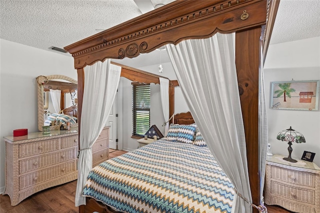 bedroom with a textured ceiling and dark wood-type flooring