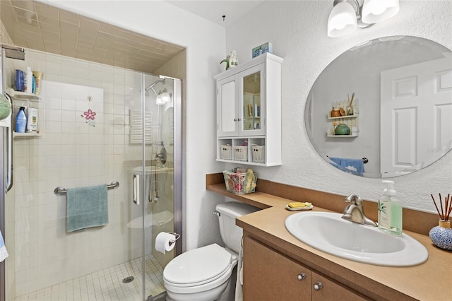 bathroom featuring vanity, toilet, and a shower with door