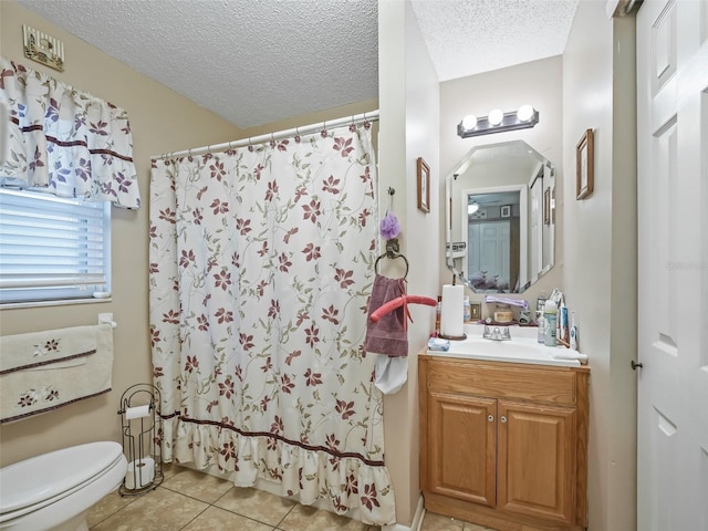 bathroom featuring toilet, tile patterned floors, vanity, a textured ceiling, and a shower with curtain