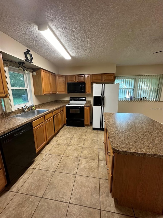 kitchen featuring black appliances, a textured ceiling, light tile patterned floors, and sink