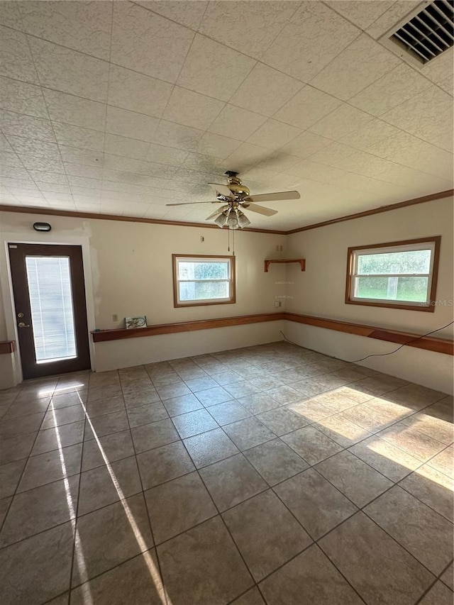 tiled spare room with ceiling fan and ornamental molding