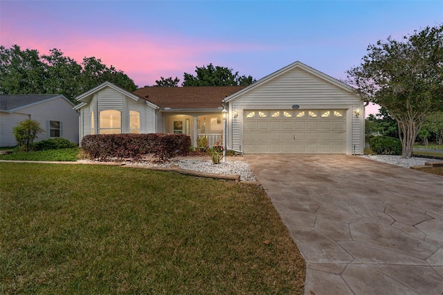 ranch-style house featuring a yard and a garage