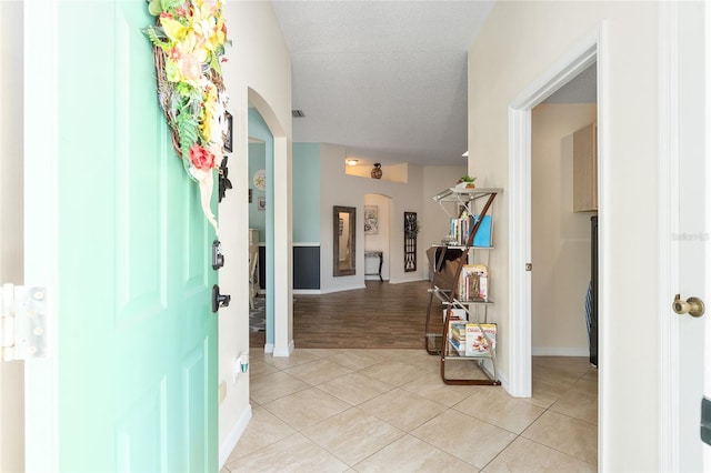 entryway with light hardwood / wood-style floors and a textured ceiling