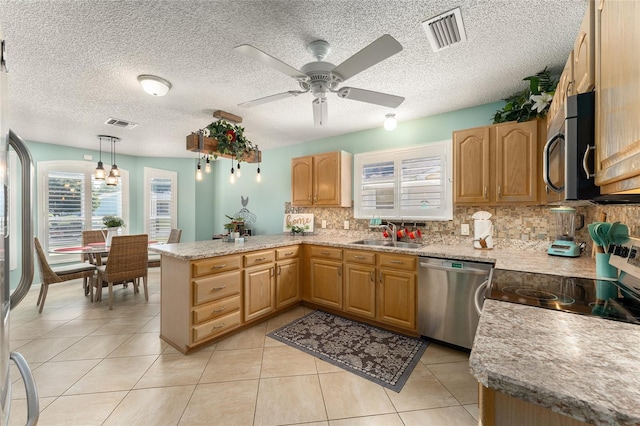 kitchen with stainless steel appliances, kitchen peninsula, sink, ceiling fan, and hanging light fixtures