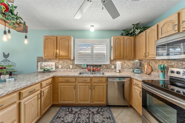 kitchen featuring backsplash, light tile patterned floors, stainless steel appliances, sink, and ceiling fan