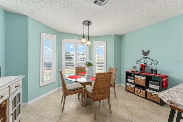 tiled dining space featuring a textured ceiling