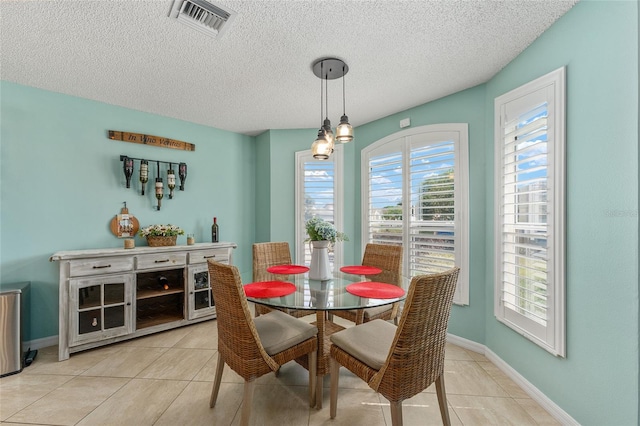 dining room featuring a textured ceiling, a chandelier, and light tile patterned floors