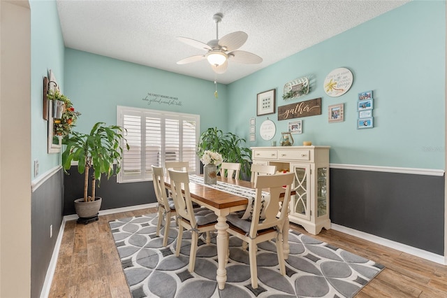 dining room with a textured ceiling, ceiling fan, and light hardwood / wood-style floors