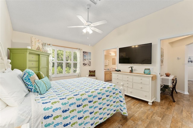 bedroom with ensuite bathroom, vaulted ceiling, light hardwood / wood-style flooring, ceiling fan, and a textured ceiling