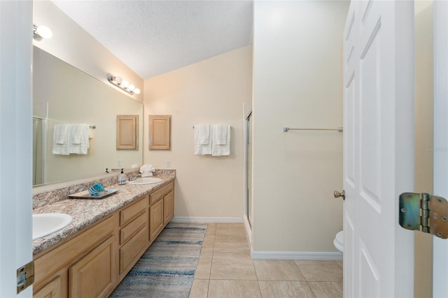 bathroom with toilet, tile patterned flooring, a shower with door, vanity, and a textured ceiling